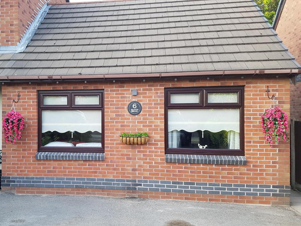 a brick building with two windows and a roof at Seaton Brook Apartment in Liverpool