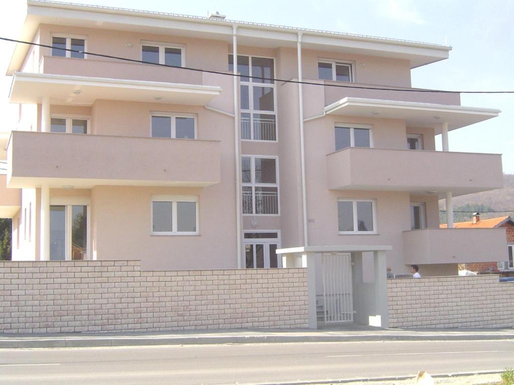 różowy budynek apartamentowy z ceglaną ścianą w obiekcie Apartmani Almica w Zagrzebiu