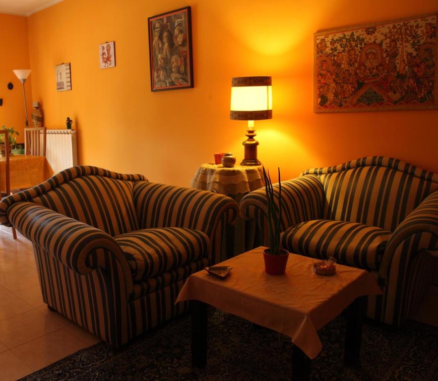 uma sala de estar com dois sofás e uma mesa com um candeeiro em B&B La Villetta em Benevento