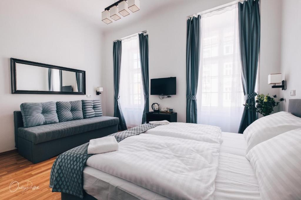 a bedroom with two beds and a couch and a mirror at Residence Corto Old Town in Prague
