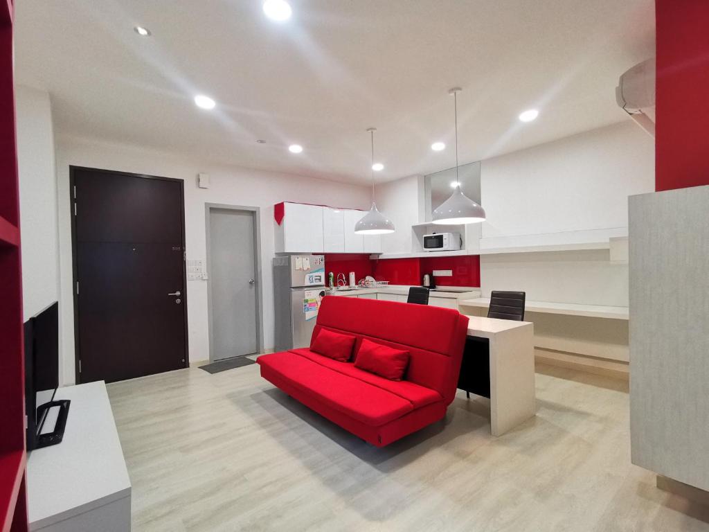 ein Wohnzimmer mit einem roten Sofa und einer Küche in der Unterkunft Strait Garden Studio X Ace Pro @ George Town in George Town