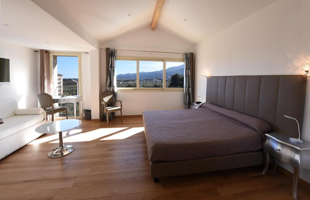 a bedroom with a bed and a couch and a table at Castellu Rossu in Lucciana