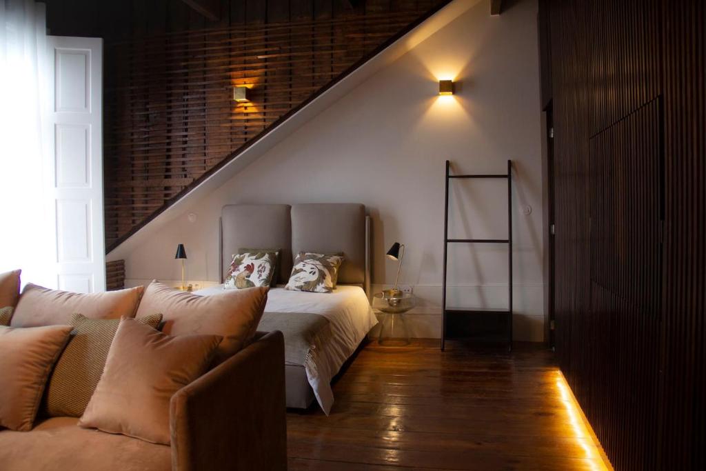 1 dormitorio con 1 cama y 1 sofá en Bateira's Apartments en Oporto
