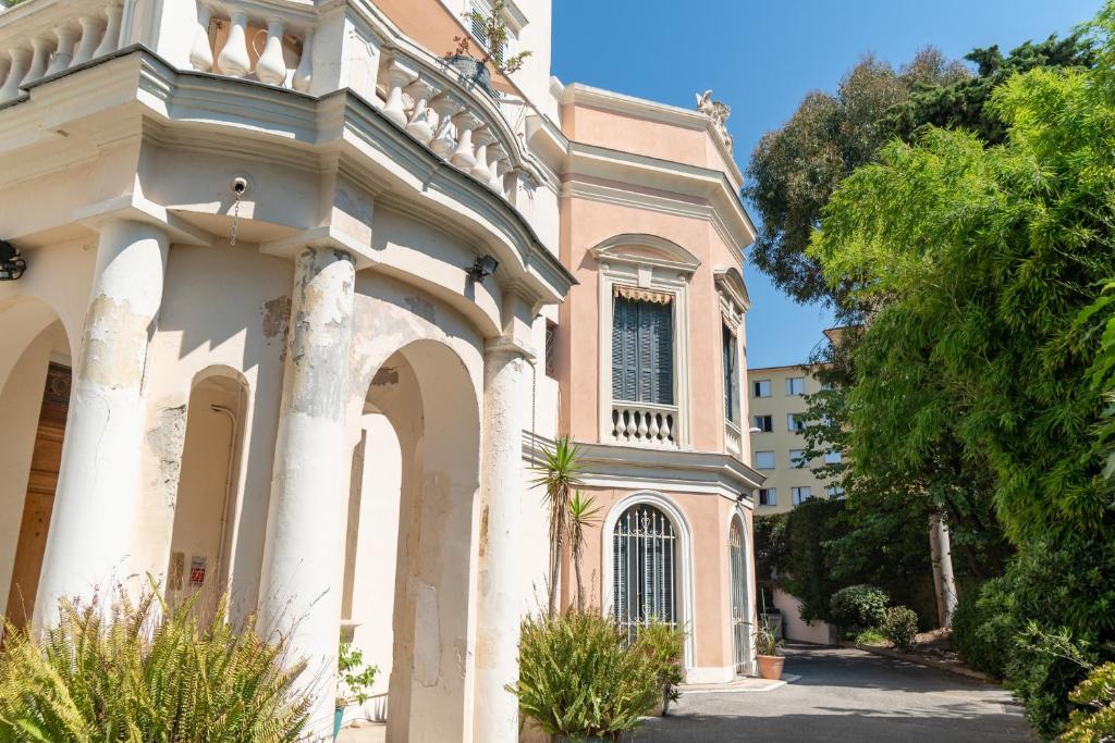 un bâtiment avec colonnes et fenêtre sur une rue dans l'établissement Apartment Villa Anahit, à Nice