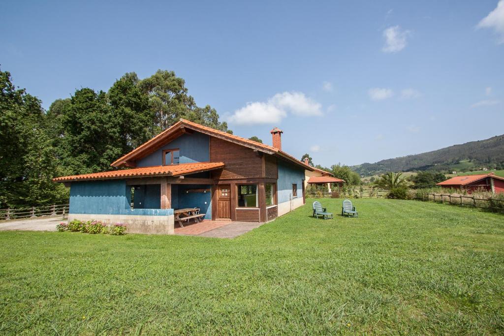 a blue house with two chairs in a yard at Primorías Boquerizo in Boquerizo