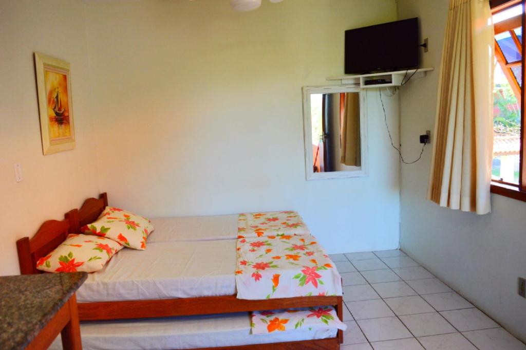 a small bedroom with a bed and a window at Moradas Costta Sul in Garopaba