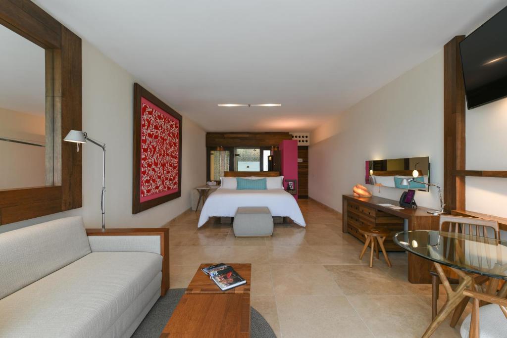 een hotelkamer met een bed en een bank bij Hotel Xcaret Mexico All Parks All Fun Inclusive in Playa del Carmen