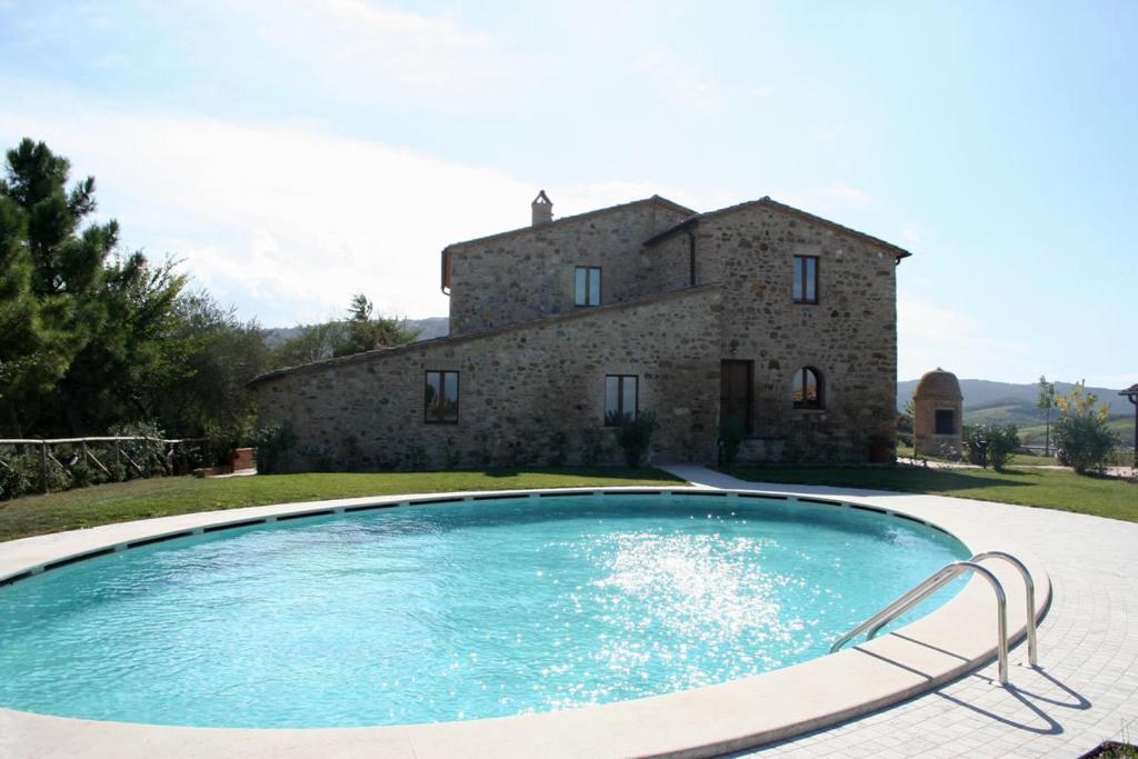 a large swimming pool in front of a building at Agriturismo Collodi in Montalcino