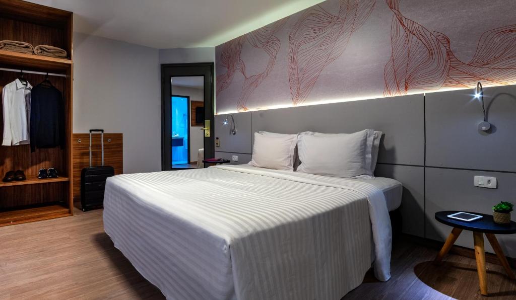 1 dormitorio con 1 cama blanca grande en una habitación en Intercity Interative São Paulo Jardins, en São Paulo