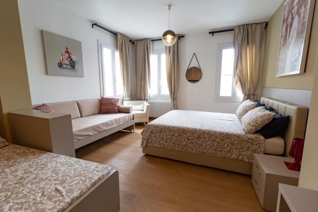 ein Wohnzimmer mit 2 Betten, einem Sofa und einem Sofa in der Unterkunft LA CASA QUADRA in Fontanelle