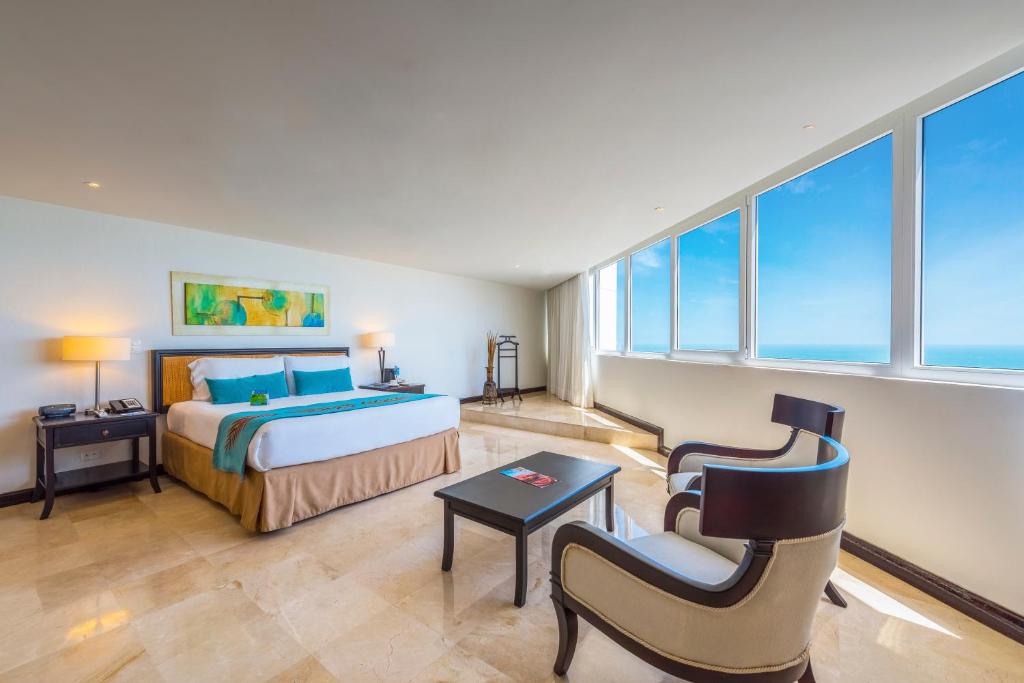 カルタヘナ・デ・インディアスにあるHotel Almirante Cartagena Colombiaのベッドと椅子付きのホテルルーム