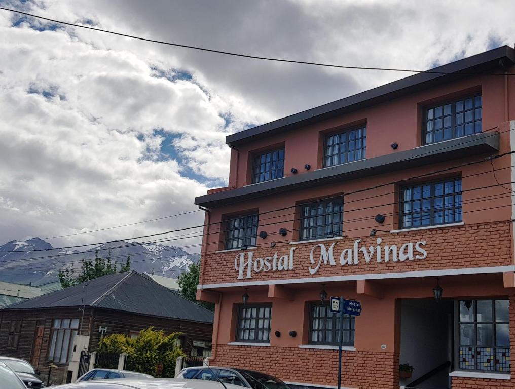 un edificio con un cartel en la parte delantera en Hostería Hostal Malvinas en Ushuaia