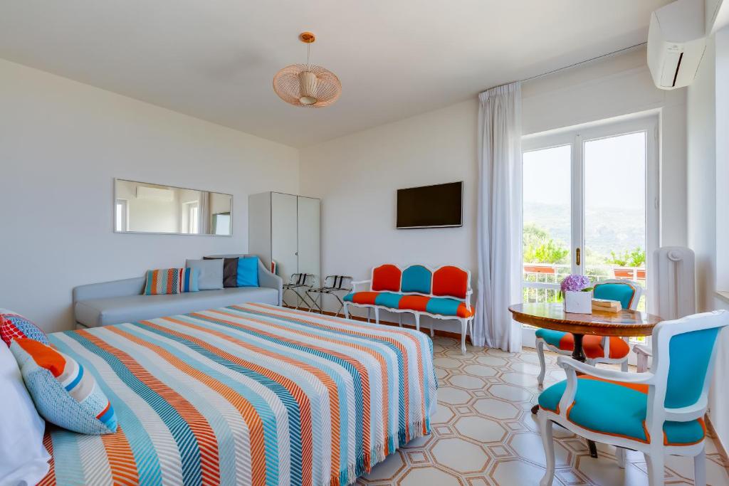 une chambre avec un lit, une table et des chaises dans l'établissement Villa Sorrento Flats, à Sorrente