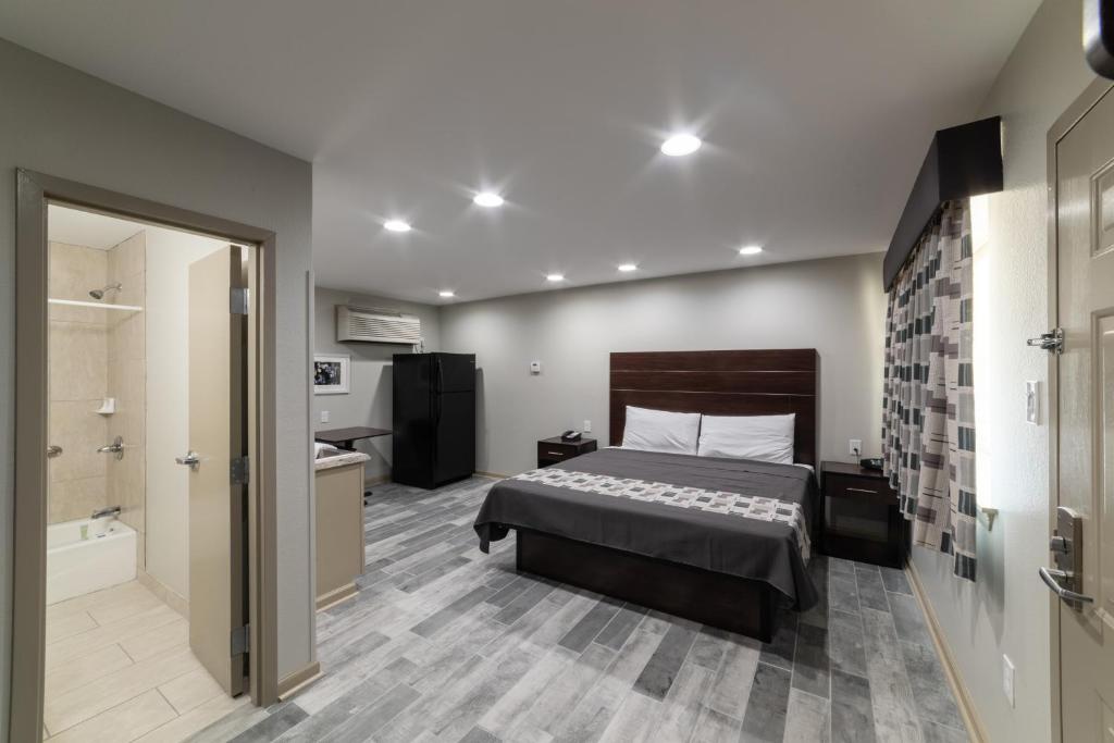- une chambre avec un lit et une salle de bains pourvue d'une baignoire dans l'établissement Budget Inn & Suites Baton Rouge, à Bâton-Rouge