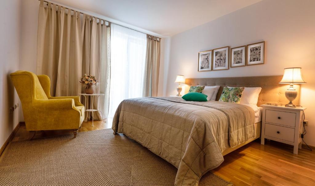 a bedroom with a bed and a chair and a window at Apartment Štefánka in Púchov