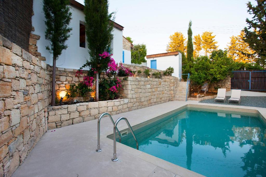 una piscina frente a una casa con una pared de ladrillo en Cecilias Courtyard, en Malya