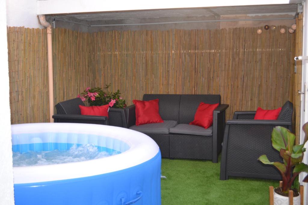 a patio with a hot tub and a couch and chairs at La Bulle des familles•jacuzzi•wifi•airport shuttle in Carcassonne