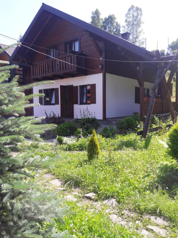 a house in the middle of a field of grass at Котедж in Vorokhta