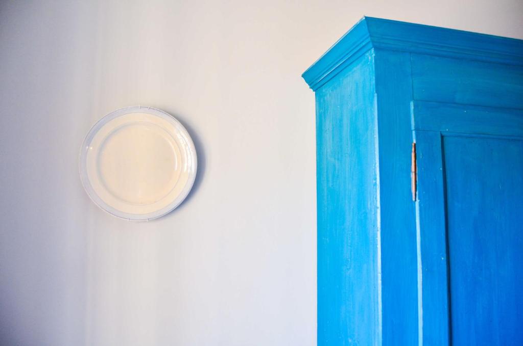 una porta blu con un piatto appeso a un muro di Atlante a Toscolano Maderno