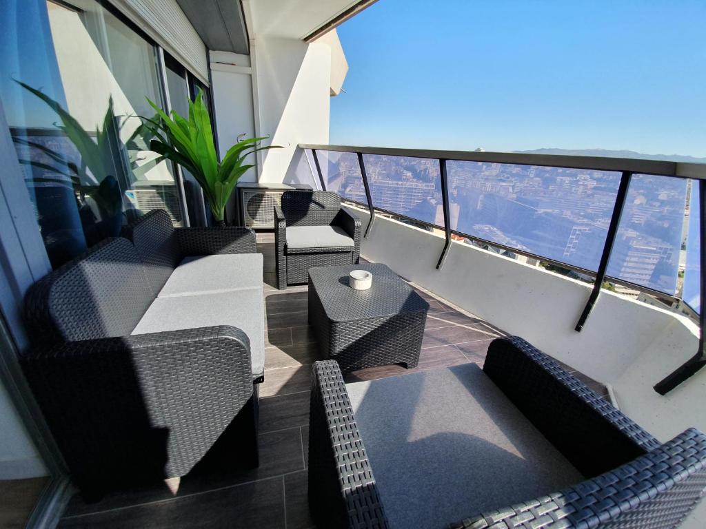 a balcony of a building with chairs and tables at Appartement T2 Prado Chanot Plage Marseille in Marseille