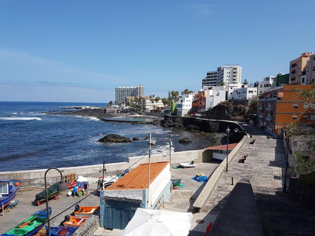 a view of a beach with buildings and the ocean at Surfing the Blue II in Punta del Hidalgo
