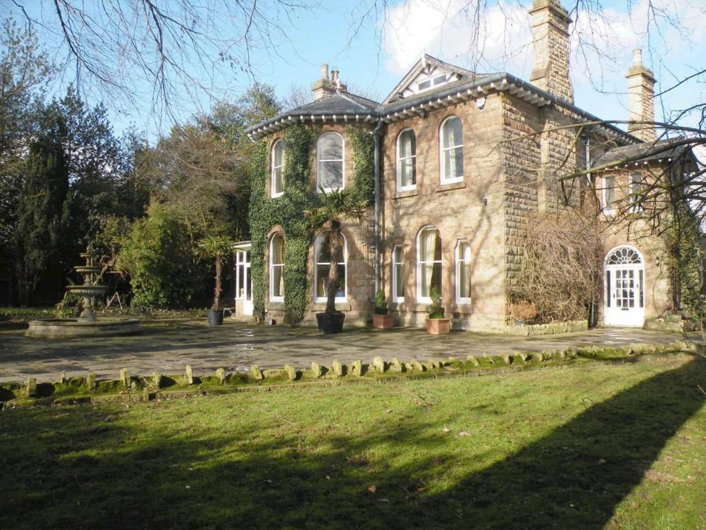 a large stone house with a large yard at Ravenscroft B&B in Mansfield