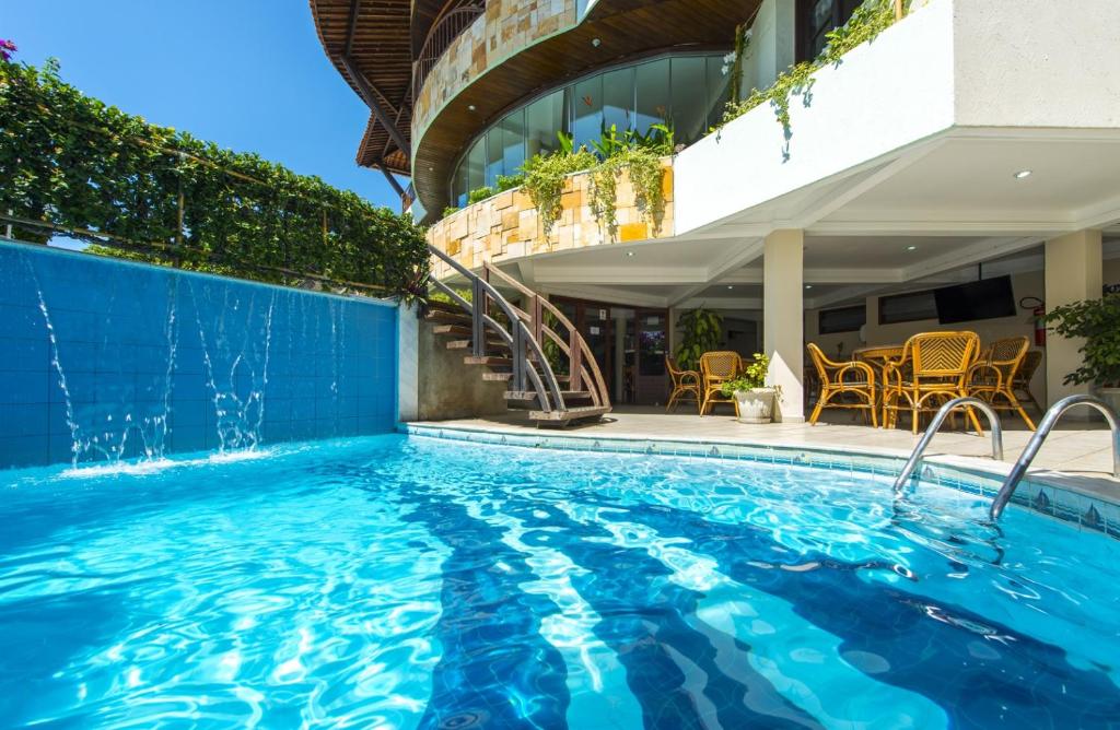 uma piscina ao lado de um edifício em Divi-Divi Praia Hotel em Natal