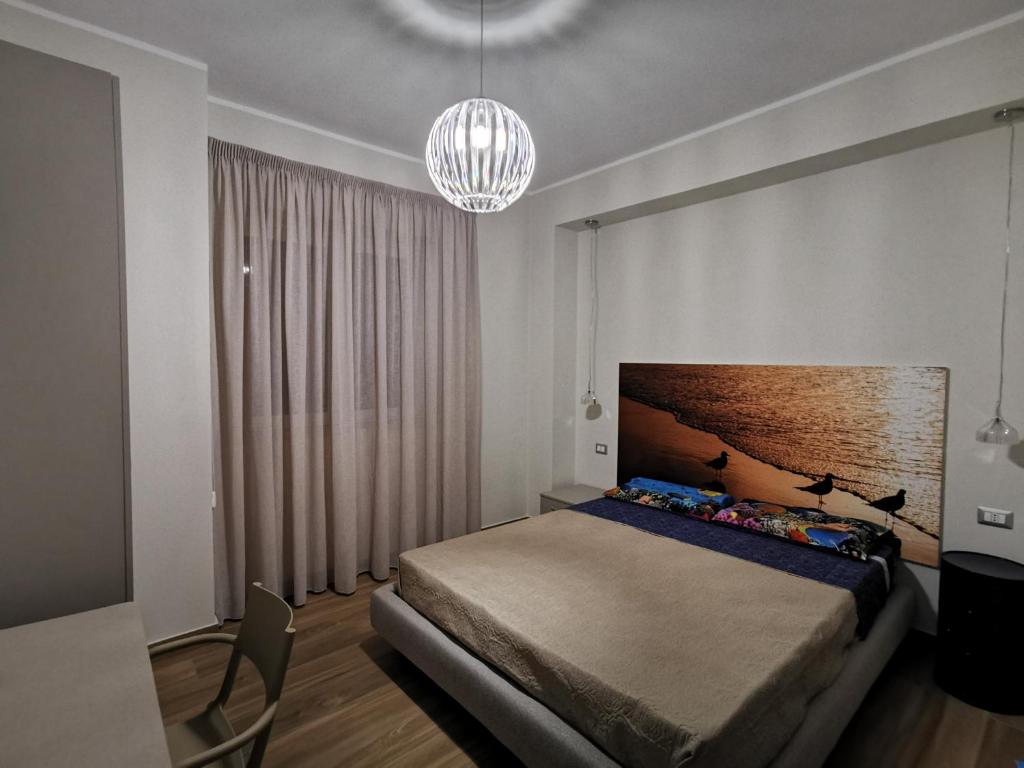 a bedroom with a bed and a chandelier at Il Microcosmo in Marina di Gioiosa Ionica