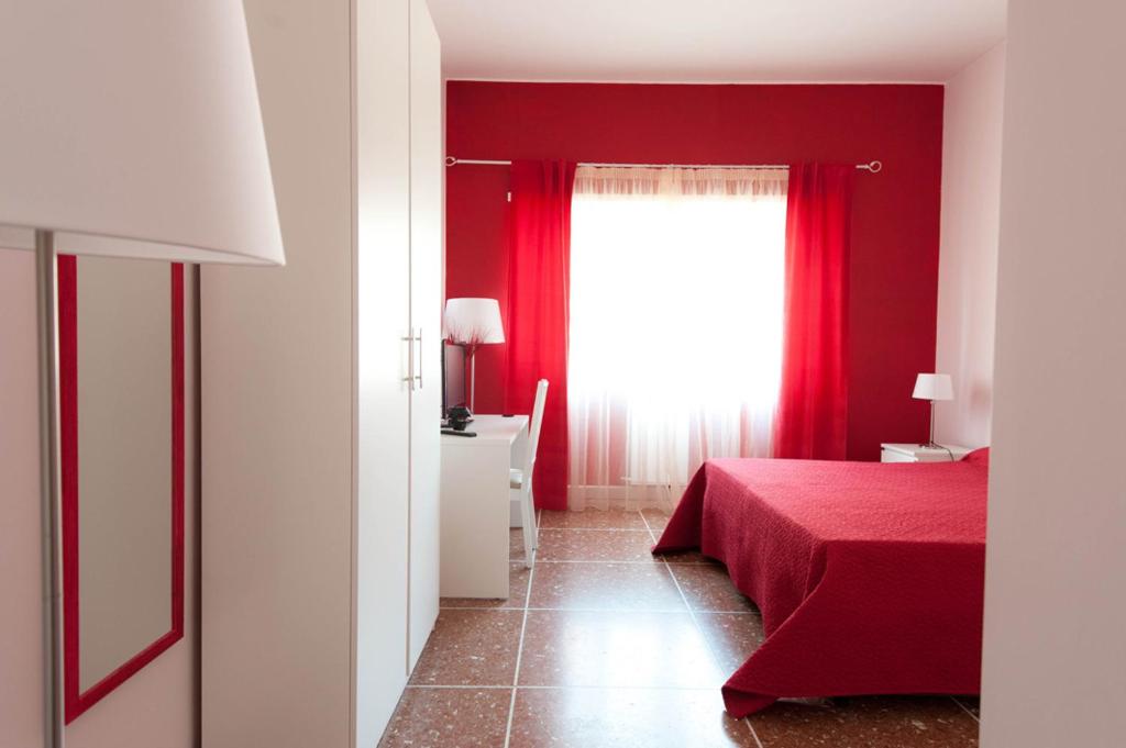 ローマにあるParco Delle Valliの赤いベッドと窓が備わる赤いベッドルーム1室が備わります。
