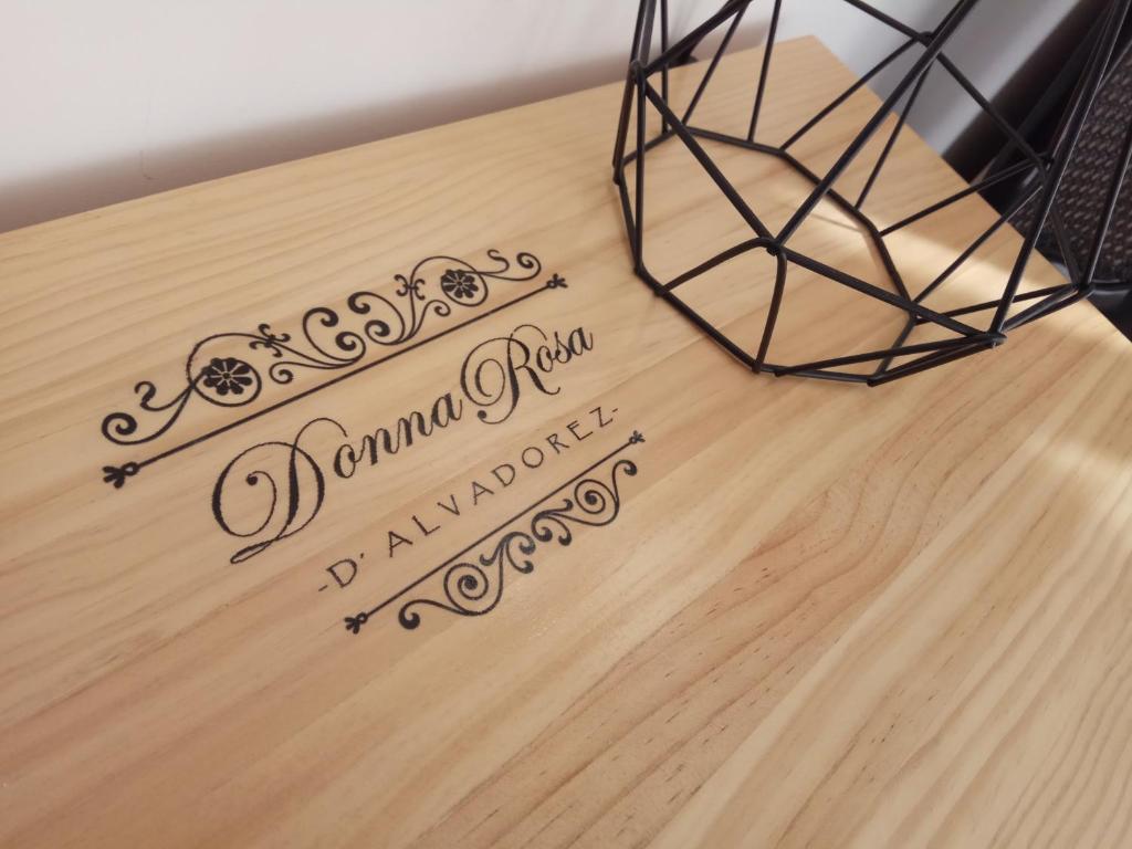 una mesa de madera con un cartel en la parte superior en Mini-apartment Donna Rosa D'Alvadorez, en Alicante