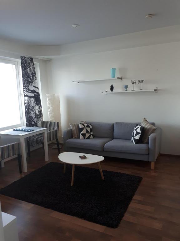 salon z kanapą i stołem w obiekcie Kaira Apartments w mieście Rovaniemi