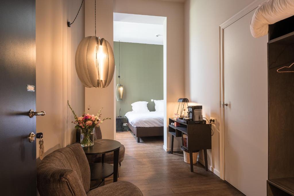 a room with a bedroom with a bed and a table at Zakske13 - Design Boutique B&B in Bruges city centre in Bruges