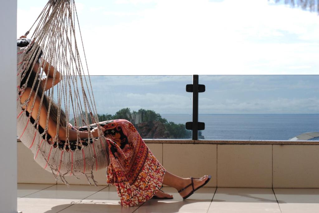 a woman in a dress sitting in a hammock at Amazon Pier Hostel in Macapá