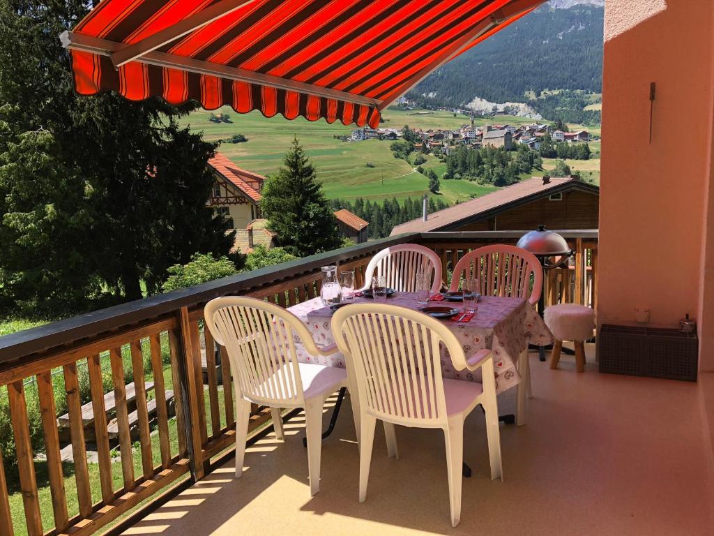 d'une table et de chaises sur un balcon avec vue. dans l'établissement Abitaziun Silvia Sur Baselgia, à Cunter