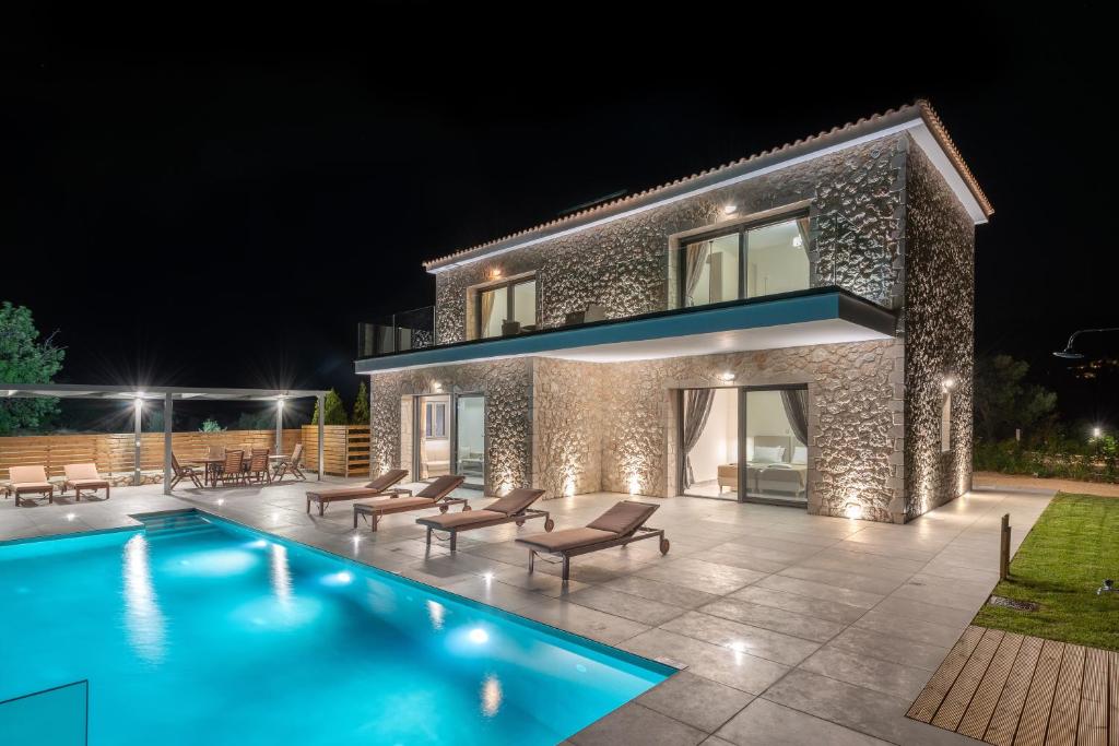 Villa con piscina por la noche en Kefalonia Stone Villas - Villa Petros Kefalonica en Trapezaki