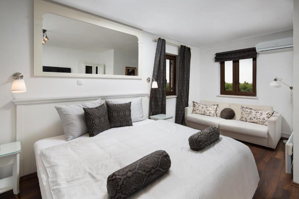 a bedroom with a white bed with two pillows on it at Villa Luka in Višnjan