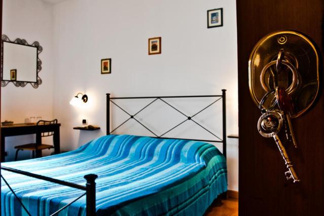 a bedroom with a bed with a blue blanket and a desk at B&B Acquedotti Antichi in Rome