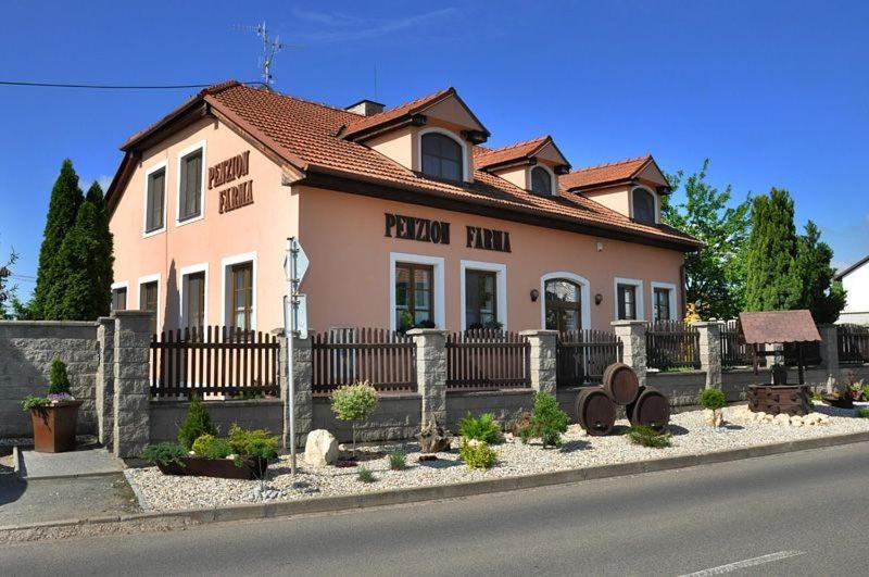 ein Haus an der Seite einer Straße mit einem Zaun in der Unterkunft Penzion Farma in Lednice