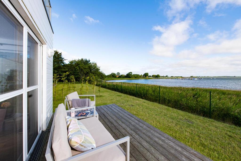 a porch with a bench and a view of the water at Strandgut in Olpenitz