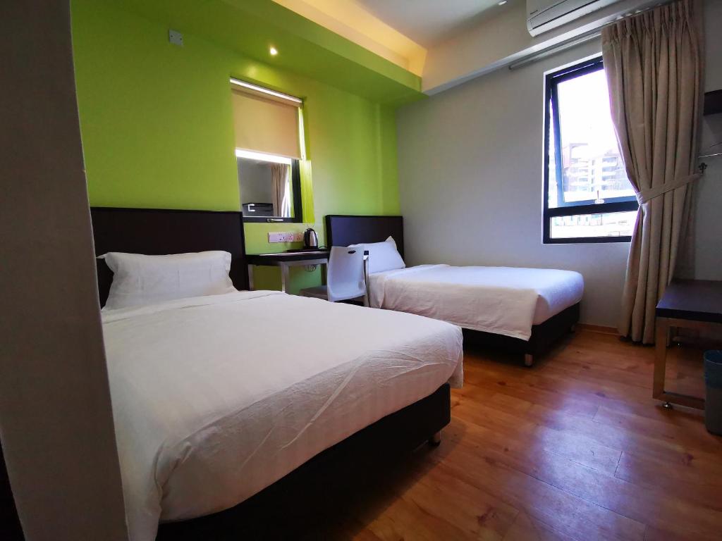 Postel nebo postele na pokoji v ubytování D'Green Hotel Kuching