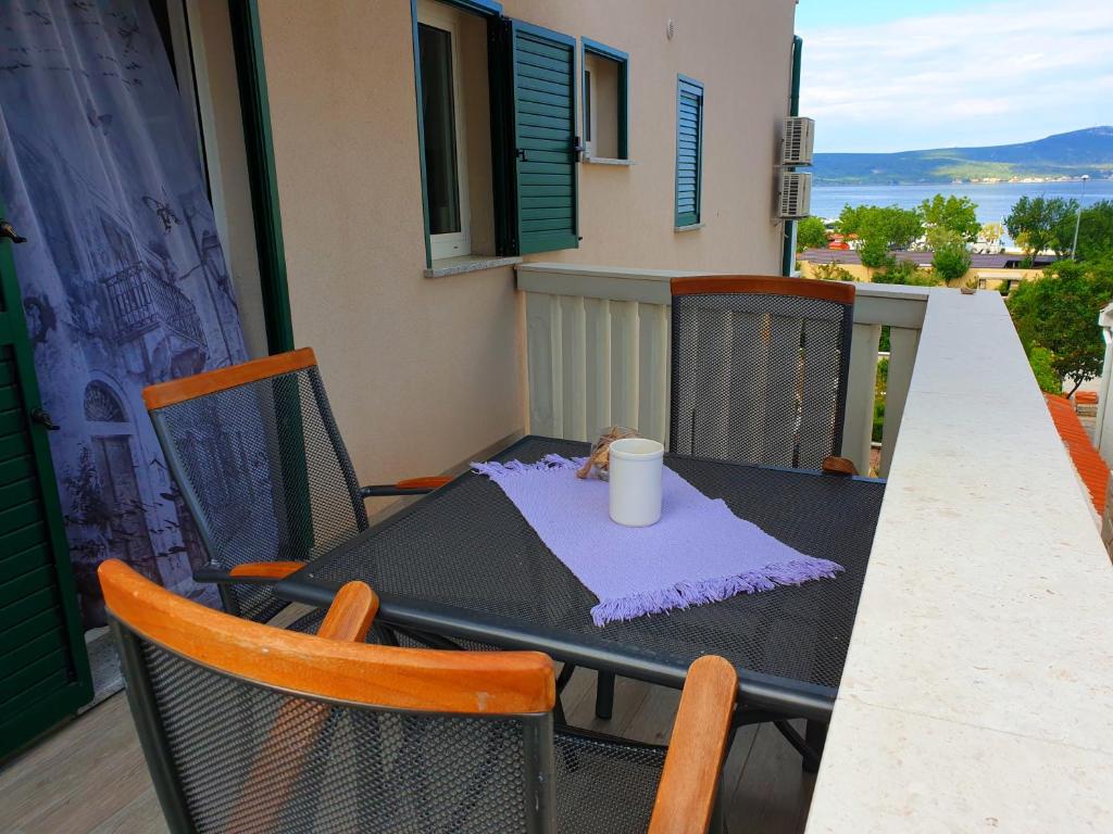 a table and chairs on a balcony with a cup on it at Cro Behar 2 Apartments in Sveti Petar