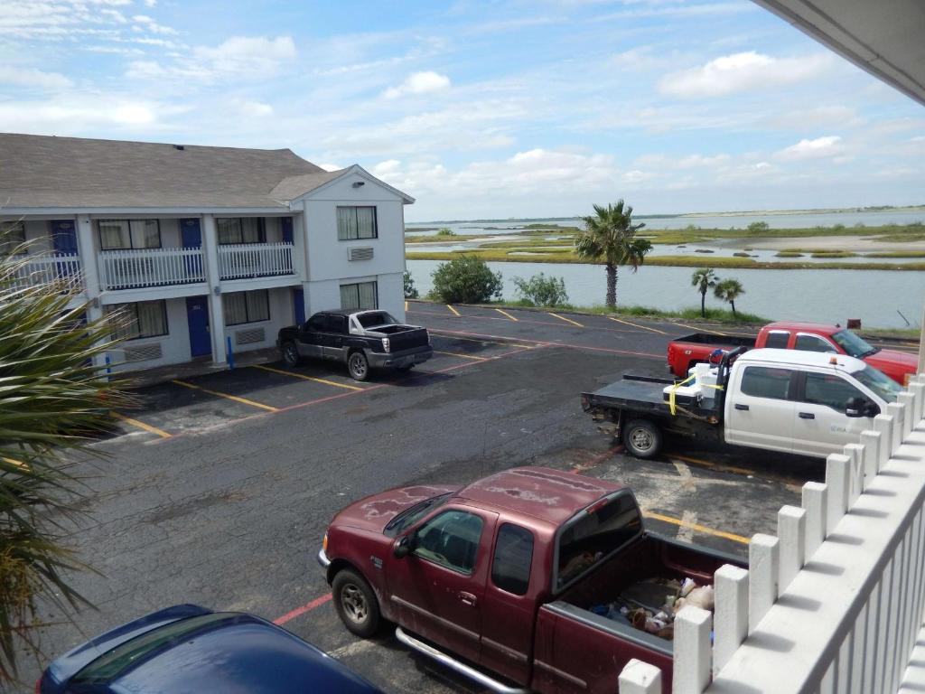 un camión rojo estacionado en un estacionamiento al lado de un edificio en Motel 6-Portland, TX, en Portland