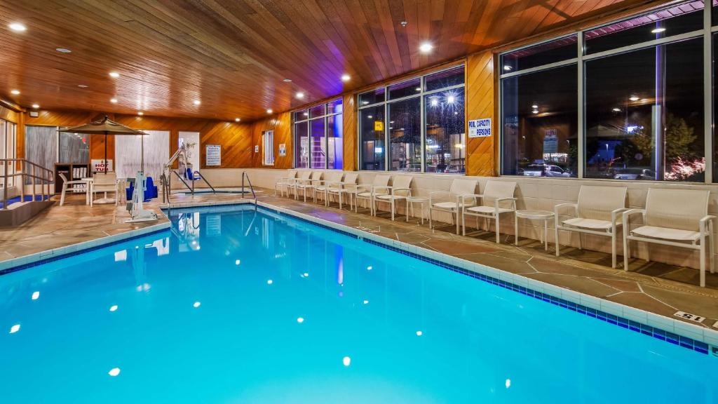 a swimming pool in a hotel with chairs around it at Best Western Plus Hudson I-94 in Hudson