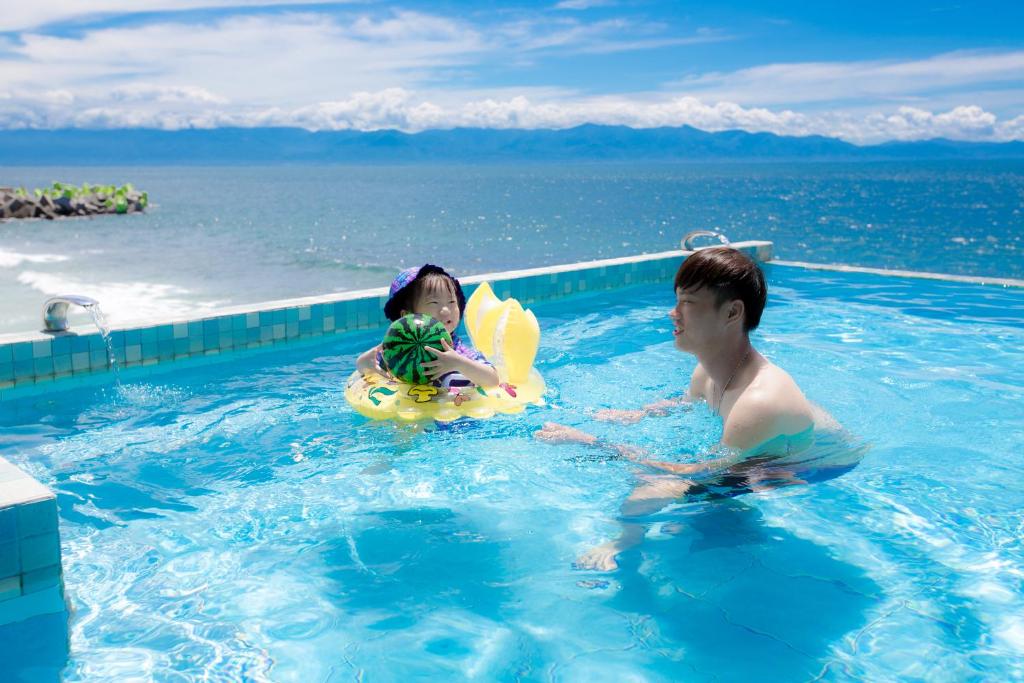 a boy and a girl in a swimming pool at Fish Villa 38 in Xiaoliuqiu