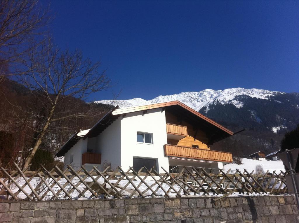 a white house with snowy mountains in the background at Landhaus Fuchsenstube in Schruns-Tschagguns