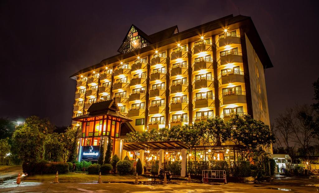 チェンマイにあるAsia Hotels Group (Poonpetch Chiangmai)の夜間照明付きの大きな建物