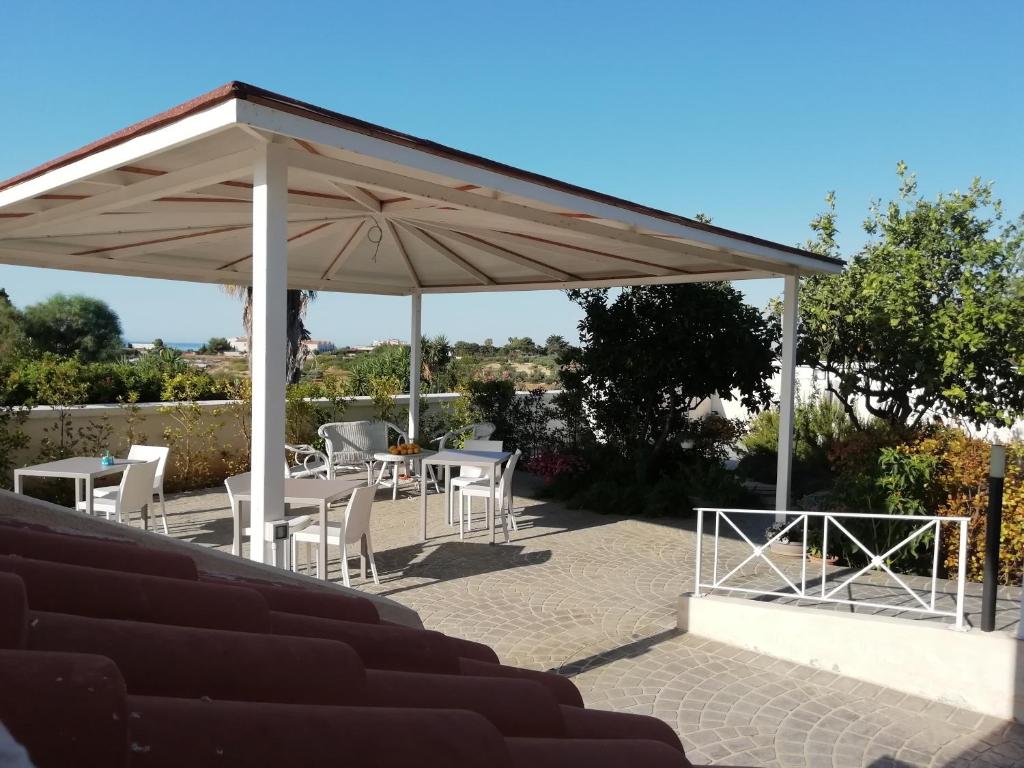 a pavilion with a table and chairs under it at Home Scala dei Turchi B&B in Realmonte