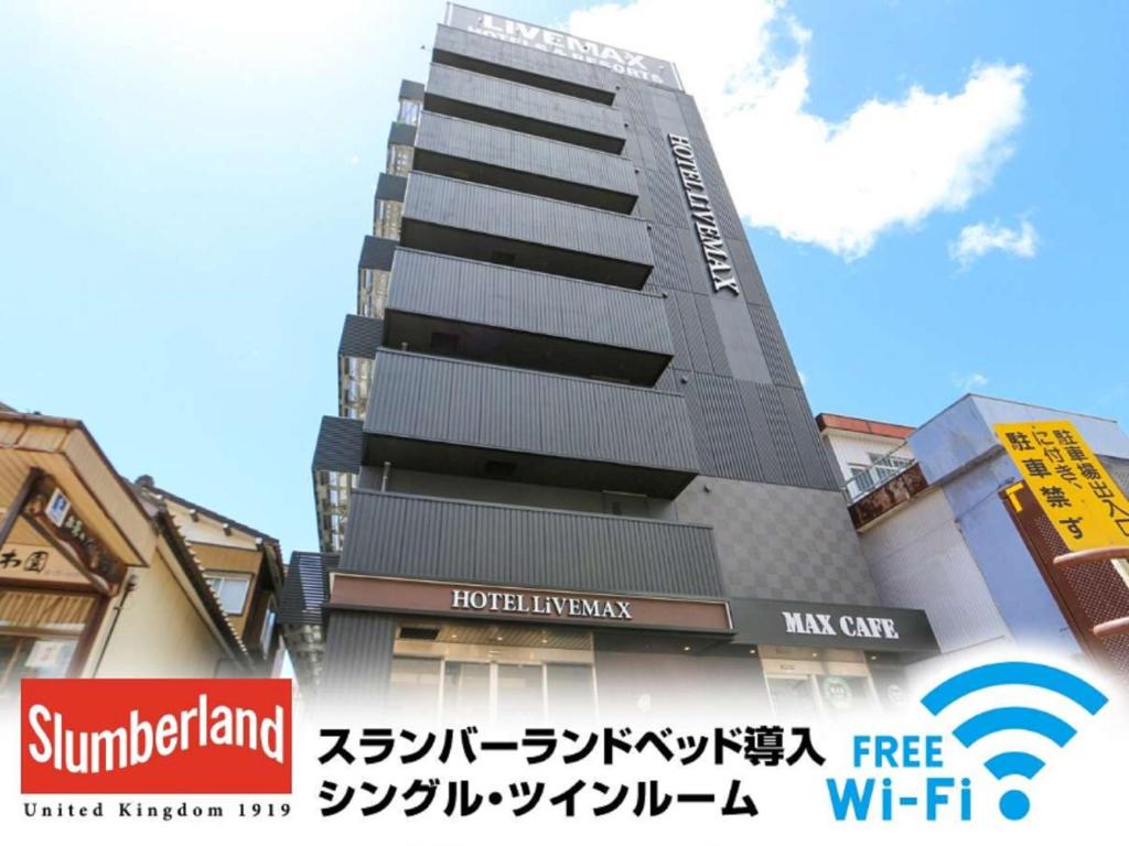 um edifício alto com um sinal em frente em HOTEL LiVEMAX Nigata Nagaoka Station em Nagaoka