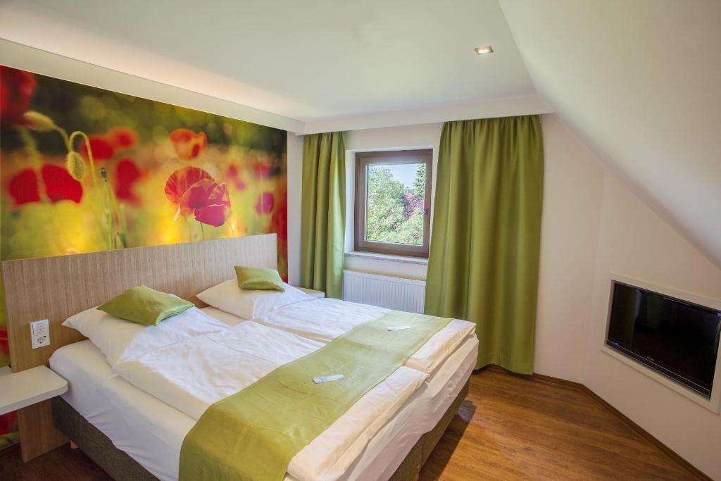 a bedroom with a large bed and a television at Gasthof Linden & Wildkräuterhotel in Windelsbach