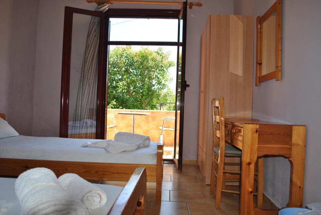 a room with two beds and a desk and a window at Magdalini Studio in Anaxos